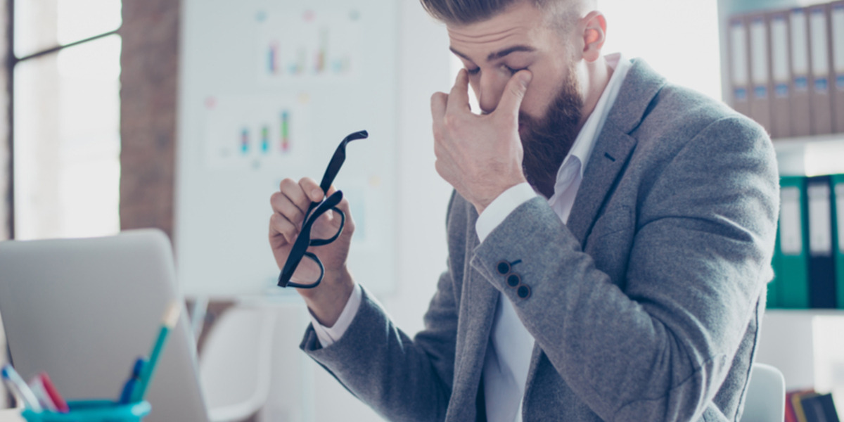 Man die voor laptop zit, wrijft in zijn ogen