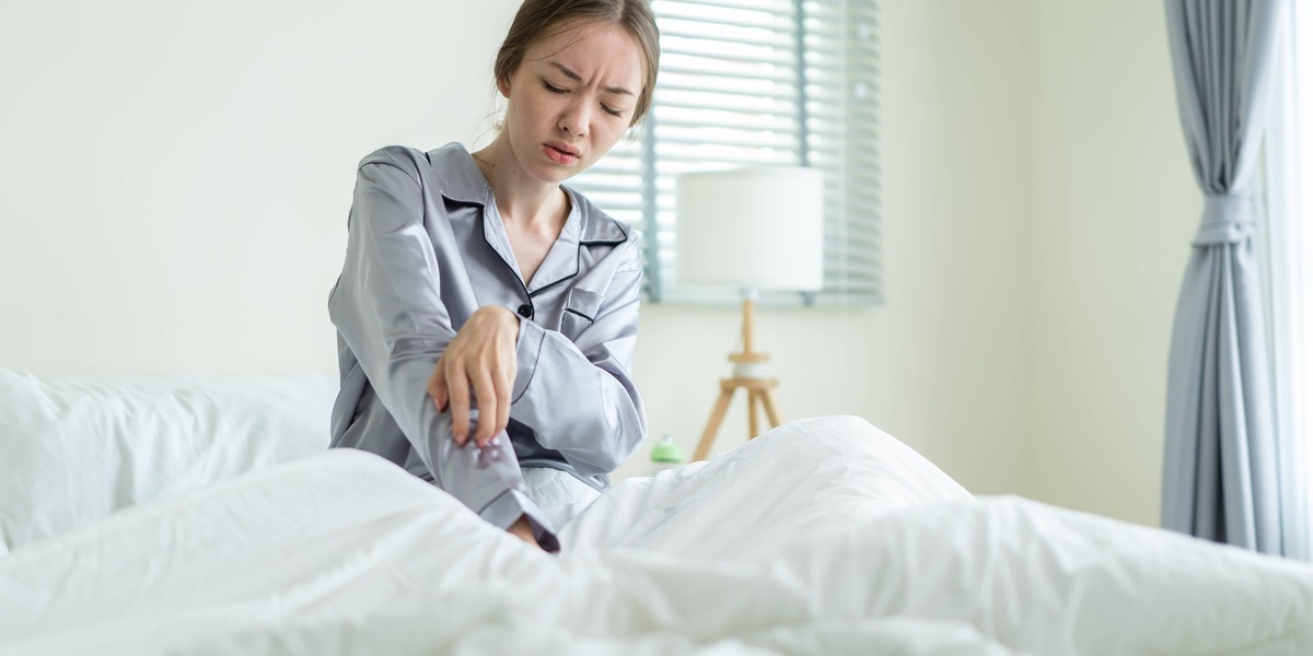 Vrouw heeft jeuk aan arm door te slapen in met schurft besmet beddensprei